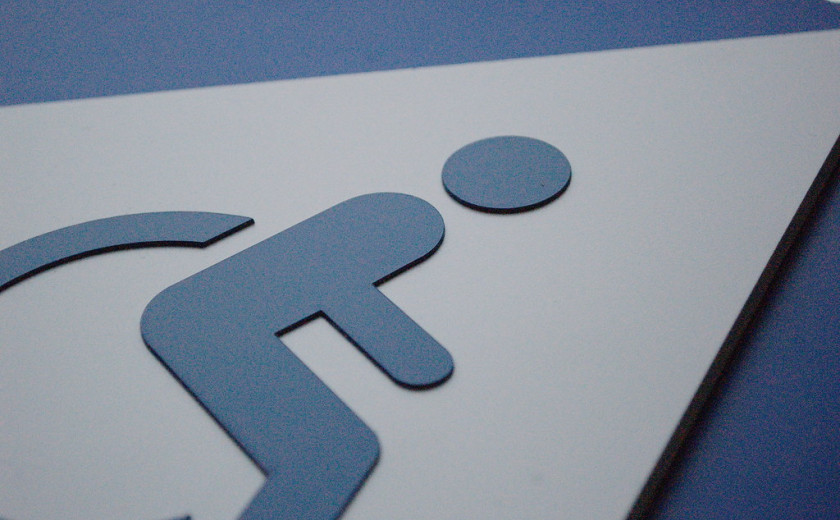 Slika znaka, na katerem je narisan invalidski voziček. Torej označuje pot dostopno za gibalno ovirane osebe.